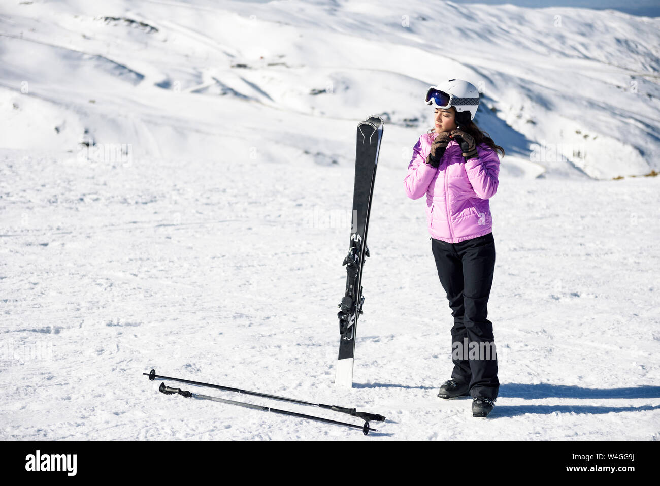 Mujer vistiendo ropa de esquí preparándose para esquiar en la Sierra Nevada, Andalucía, España Foto de stock