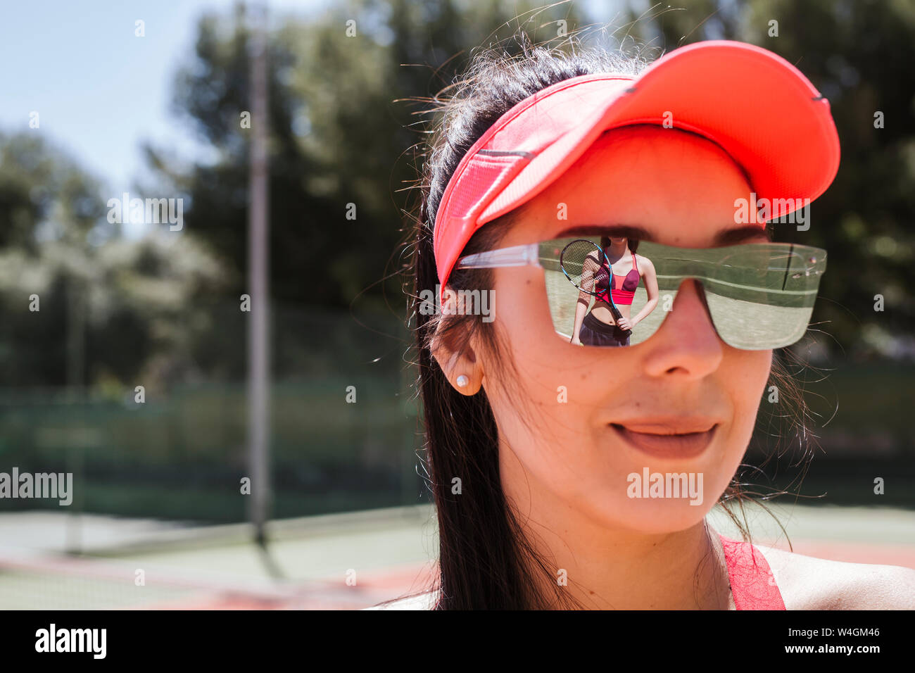 Jugador de tenis femenino reflejando en gafas de sol de mujer Foto de stock