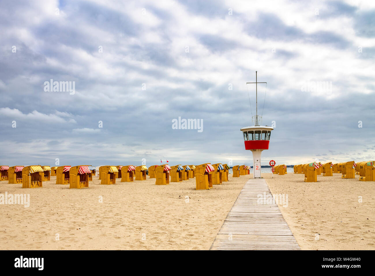 Vista a la playa con sillas de playa y encapuchados torre del operador Travemuende Luebeck, Alemania Foto de stock