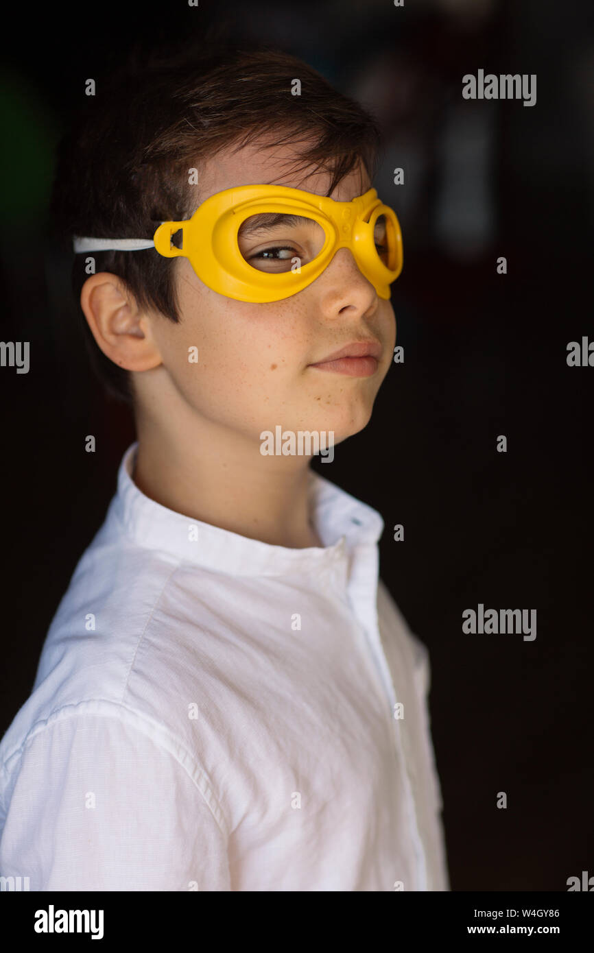 Niño usando máscara de ojo amarillo, mirando a la cámara Foto de stock