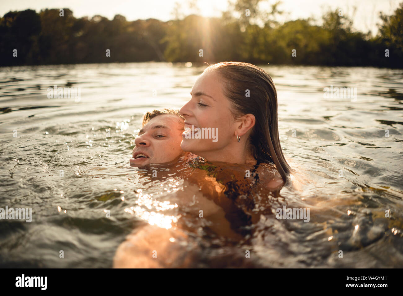 Afectuoso par nadar juntos en un lago Foto de stock