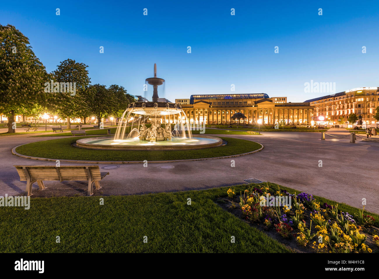 La plaza del palacio con la fuente en frente de Koenigsbau al anochecer, Stuttgart, Alemania Foto de stock
