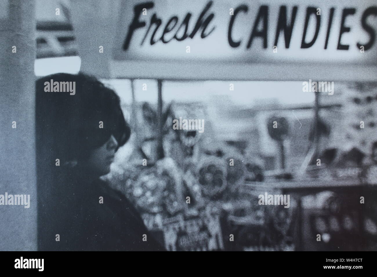 Fino arte fotografía en blanco y negro a partir de la década de 1970 de una elegante mujer de incógnito con un par de gafas de sol oscuras pesado pasando un signo "fresco". Foto de stock
