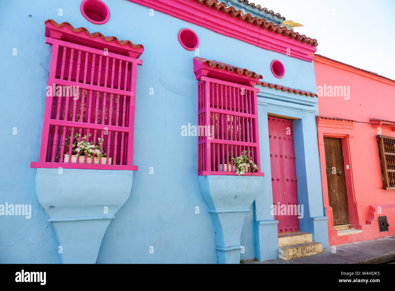 Colombia Cartagena Centro de la Ciudad amurallada Viejo Centro histórico restaurado colonial casa arquitectura fachada colores vivos rosa azul madera ventana gril Foto de stock