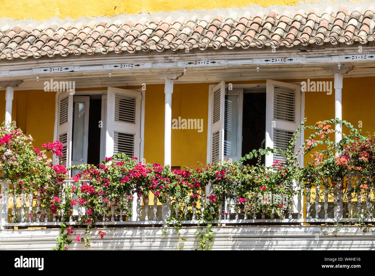 Colombia Cartagena Centro de la Ciudad de las amuralladas antiguas fachada de arquitectura colonial Balcón de madera Bougainvillea viña arcilla tejas residencial apar Foto de stock