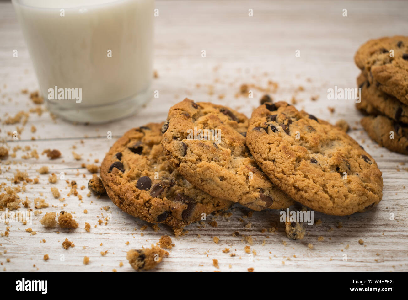 Las galletas con trocitos de chocolate con migajas sobre una mesa de madera Foto de stock