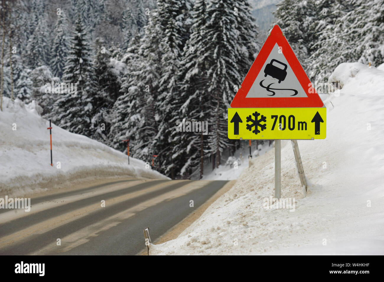 Señal de tráfico en la carretera advierte de hielo y nieve en invierno Foto de stock