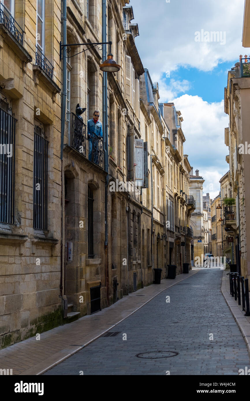 Burdeos, Francia - 5 de mayo de 2019: maniquí de un gato negro y un hombre en el balcón de un edificio residencial en el centro histórico de la ciudad de Bordeaux, Francia Foto de stock