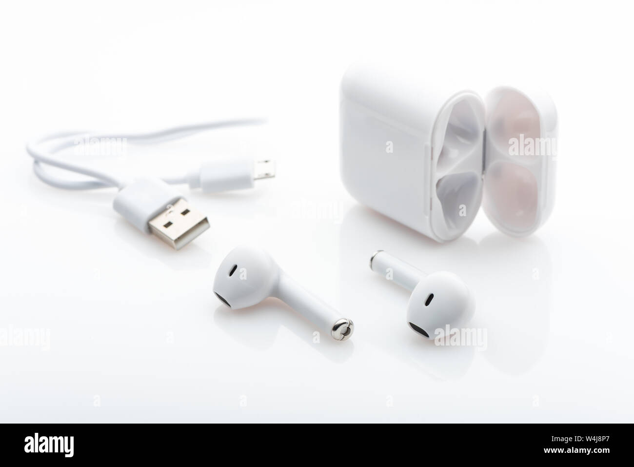 Cable de carga USB y funda para auriculares inalámbricos sobre fondo  blanco. Tecnología moderna Fotografía de stock - Alamy