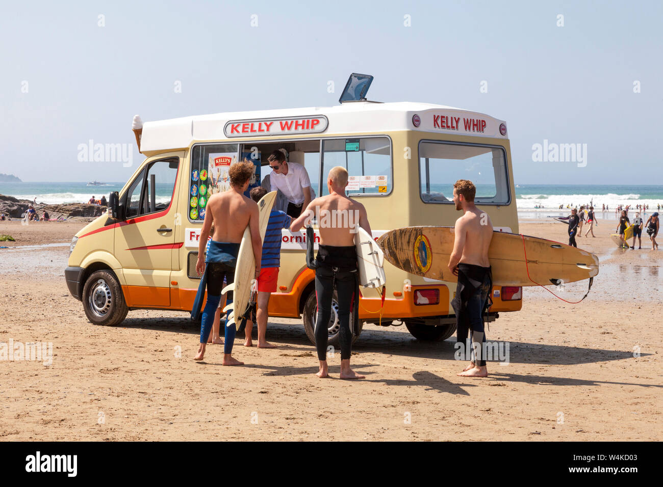 Polzeath, Cornwall. El 23 de julio de 2019. Surfers comprar helados en un caluroso y soleado por la tarde en Polzeath playa en el norte de la costa atlántica de Cornualles, Foto de stock
