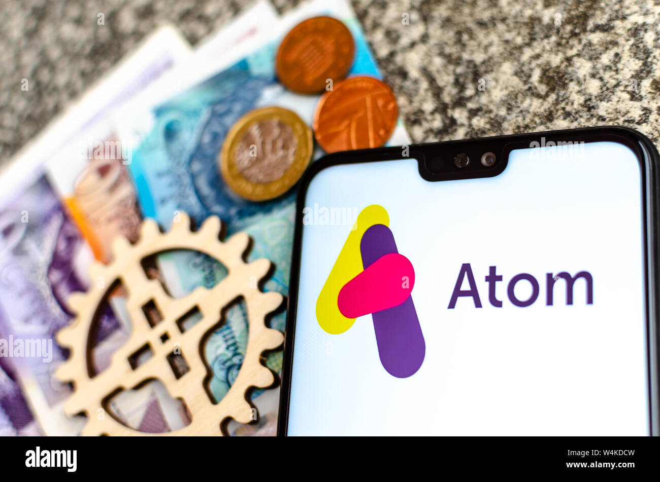 Atom logotipo del banco en la pantalla del smartphone Foto de stock