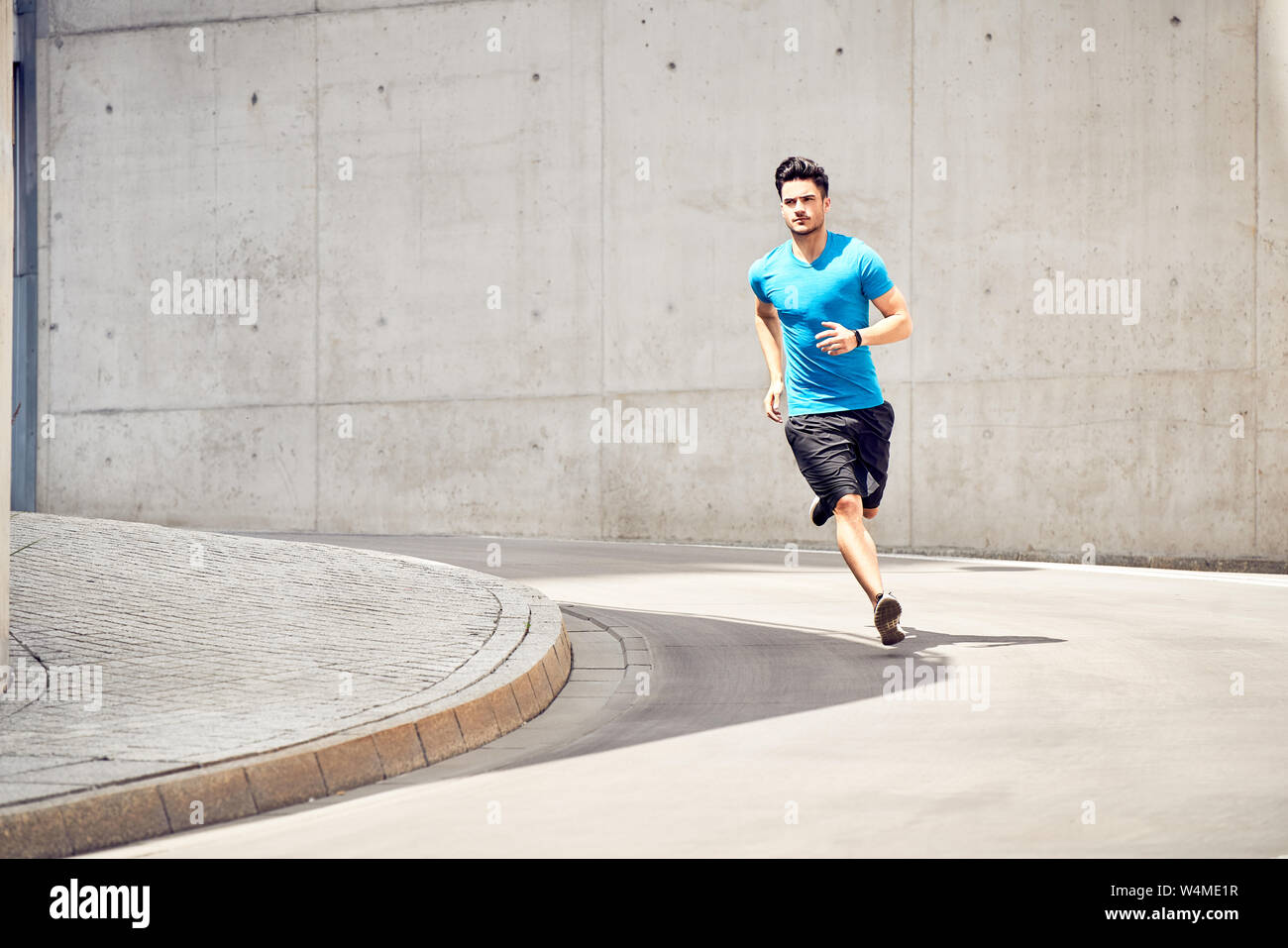 Colocar hombre corriendo durante la sesión de entrenamiento en la ciudad. Concepto de salud y deporte Foto de stock