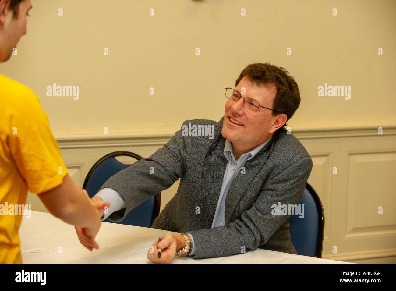 El periodista Nicholas Kristof agita las manos con un estudiante durante un simposio de Asuntos Exteriores en la Universidad Johns Hopkins en Baltimore, Maryland, 2 de febrero de 2010. Desde el Homewood fotografías. () Foto de stock