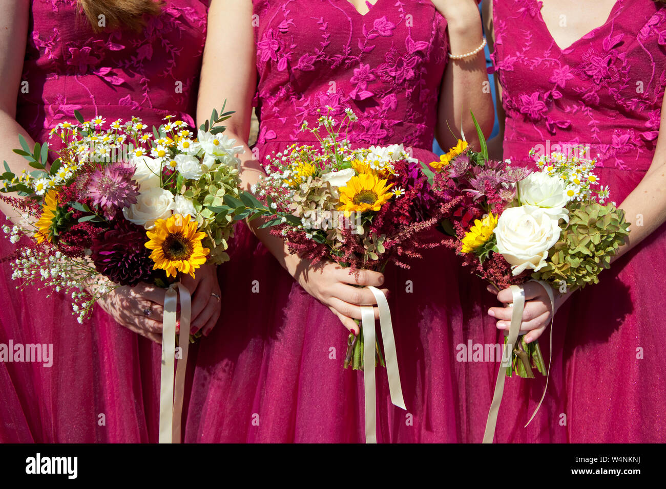 Tres damas de honor vestidos de encaje en color lila con ramos de flores  frescas, el enfoque selectivo Fotografía de stock - Alamy