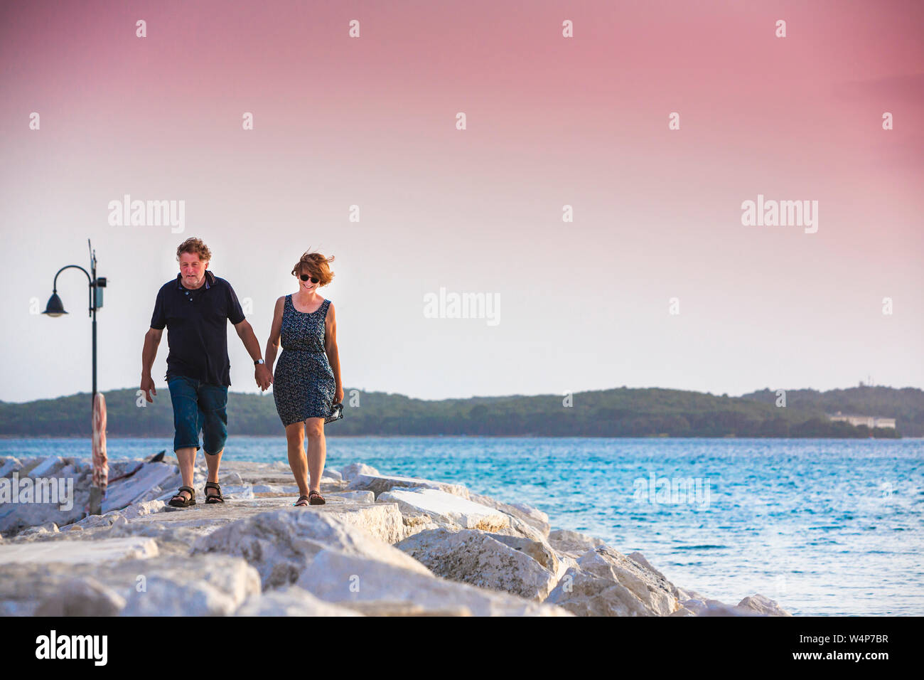 Croacia, Istria, par disfrutar del atardecer en el muelle Foto de stock