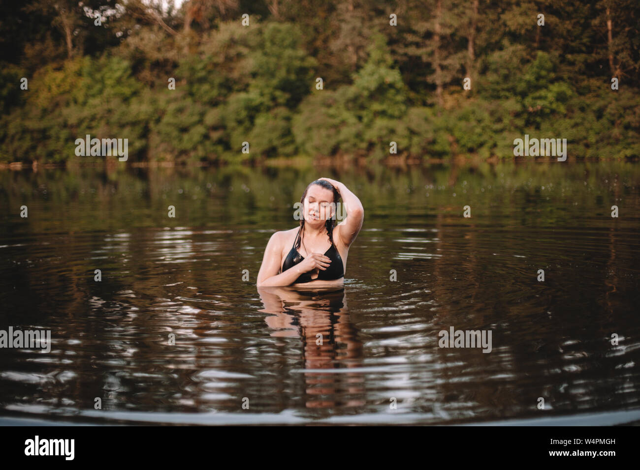 Mujer joven emergiendo del agua Foto de stock