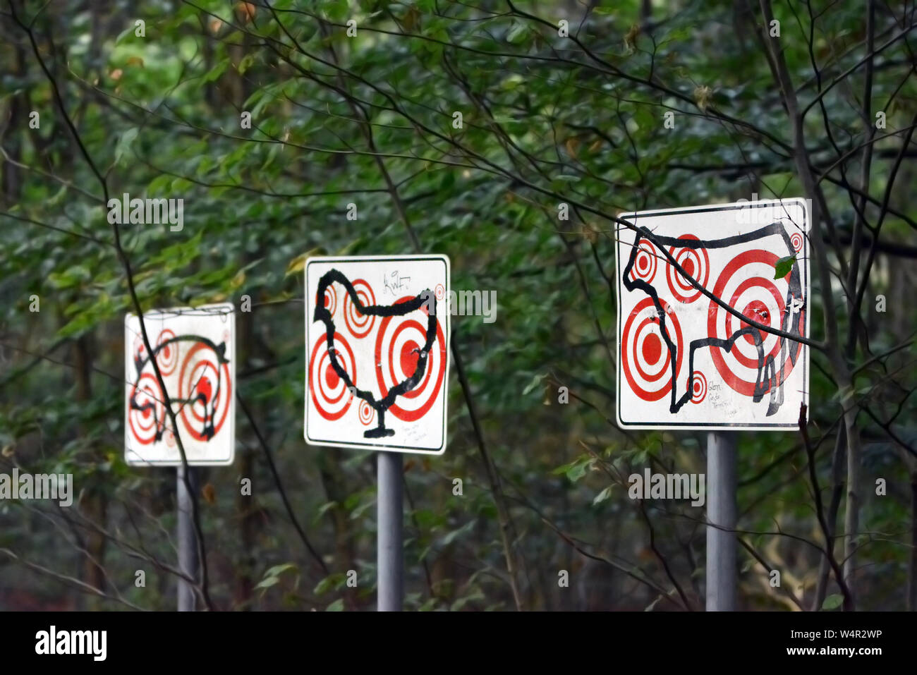 Darmstadt, Alemania , signos con contornos de animales de granja como vaca, pollo y cerdo con múltiples objetivo rojo marca en ellos como parte de la exposición de arte Foto de stock