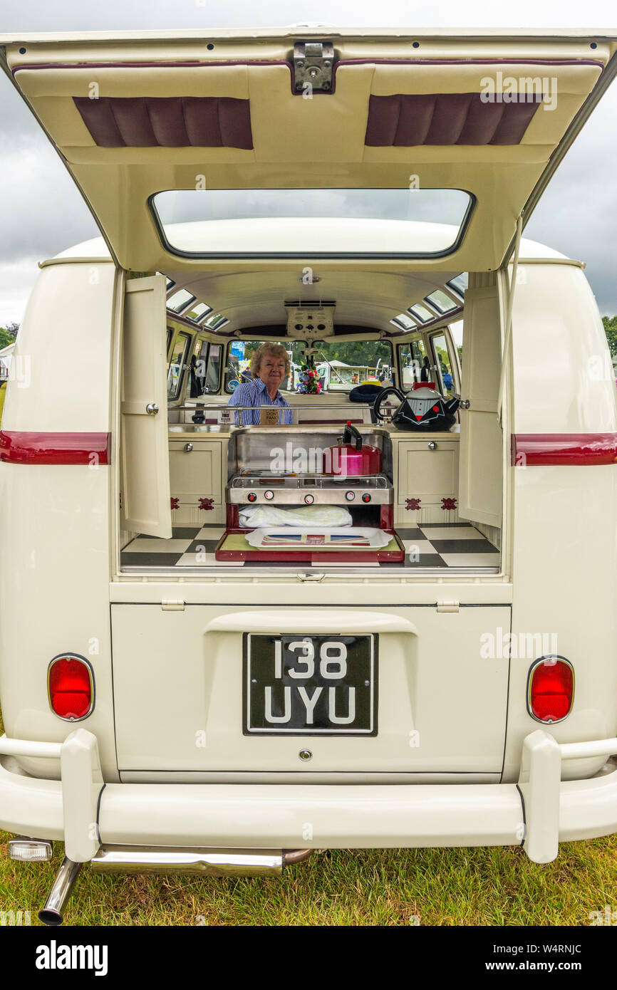 Mujer sentada en un blanco clásico VW camper van a una fiesta de verano,  Inglaterra, Reino Unido Fotografía de stock - Alamy