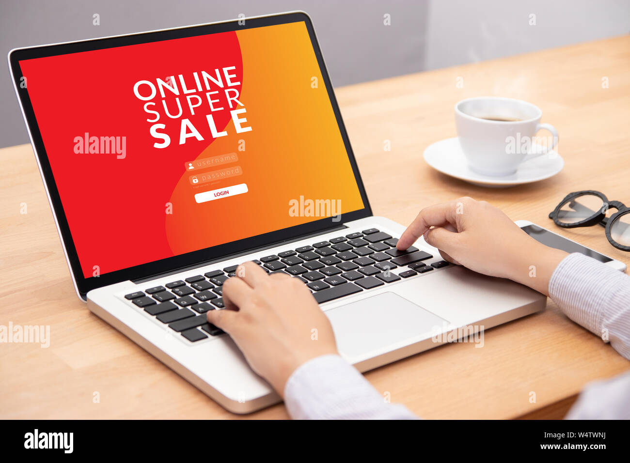 Mujer inicio de sesión con una contraseña en el ordenador portátil para hacer compras online web con promoción venta campaña de descuento en pantalla Foto de stock