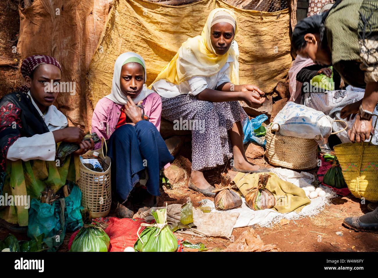 Las mujeres comerciantes que venden la mantequilla y los huevos en un mercado rural en Etiopía occidental Foto de stock