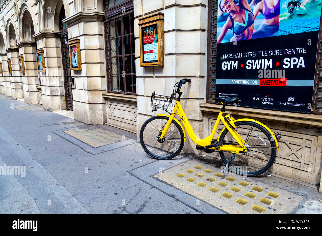 Régimen de alquiler amarillo dockless ofo bicicleta aparcado en la calle, Londres, Reino Unido. Foto de stock