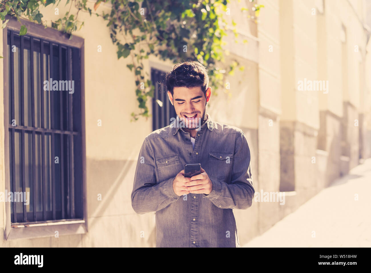 Colegio de moda hombre veinteañero feliz comprobando blog o chatear en  Internet con amigos en el teléfono móvil inteligente app en Europa la  ciudad al aire libre Fotografía de stock - Alamy