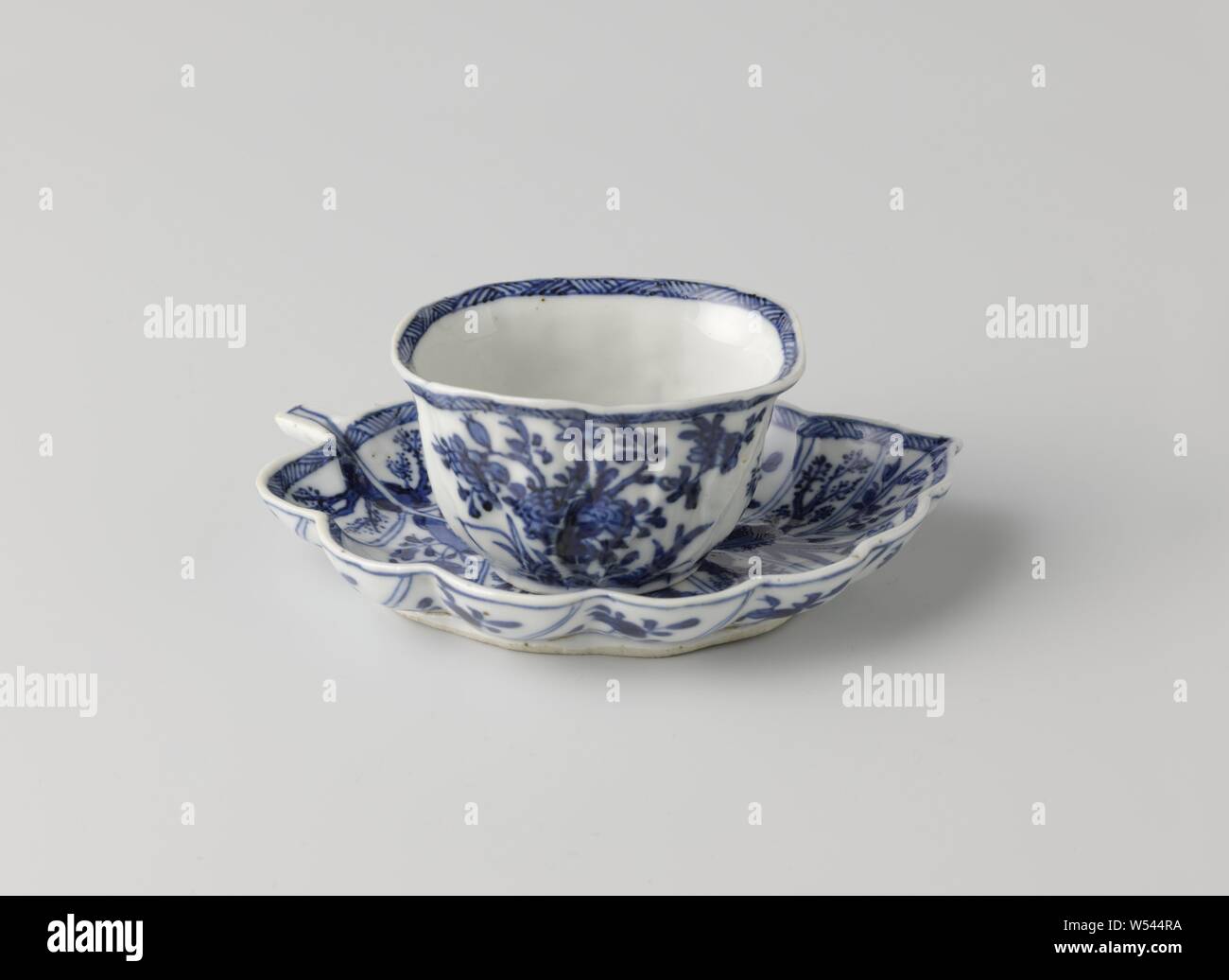 Taza con platillo en forma de una hoja, taza y plato de porcelana, el platillo en la forma de una hoja, pintado de azul underglaze. La cabeza modelada con venas en el exterior y pintados con una rama de flores flores cuatro veces, una rama de flores en la parte inferior, el interior y el exterior del borde con una banda decorativa con la eclosión. El plato está dividido con una caja decoración por los "ins" de la hoja, llena de diversas plantas en floración en una roca. Marcados en la parte inferior del plato con un lotus. Azul Blanco., anónimos, China, c. 1750 - c. 1774, la dinastía Qing (1644-1912) / Periodo Qianlong (1736-1795 Foto de stock