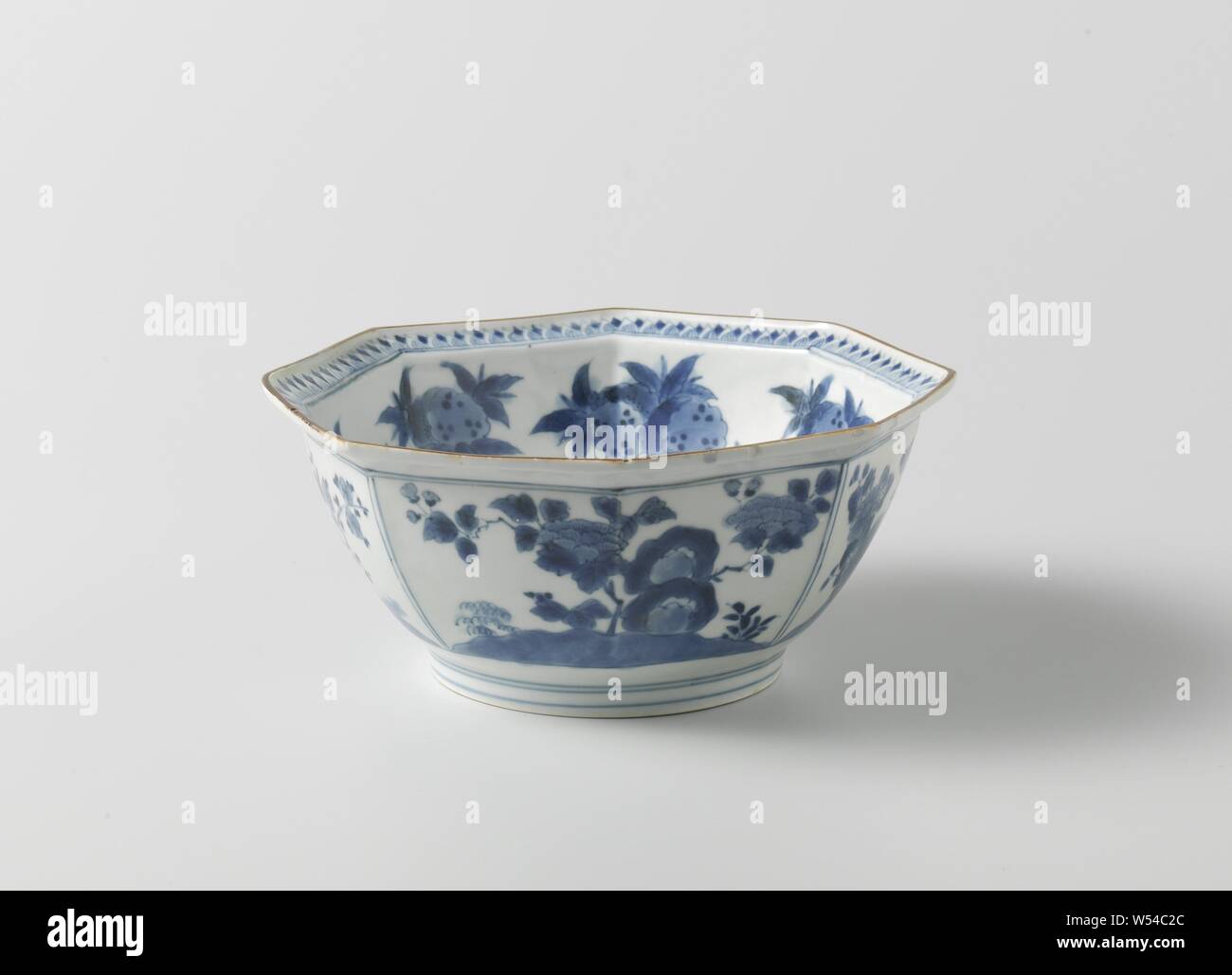 Tazón octogonal con garzas, Granados, crisantemo, peonía y Prunus, tazón octogonal de porcelana con un borde elevado, pintada en azul underglaze. En el exterior, cuatro compartimentos con plantas de floración (Chrysanthemum, Peony, prunus) cerca de una roca. En la parte inferior un medallón octogonal con un paisaje de río. El interior de la pared con dos garzas cerca de una roca con un árbol de granada. En el borde interior de una banda con motivos de hojas puntiagudo. Borde marrón. Marcados en la parte inferior con el sello mark 'chin', 'oro' en un doble cuadrado. Una pren en la parte inferior. Arita, Kakiemon en azul y blanco., anónimos, Japón, c Foto de stock