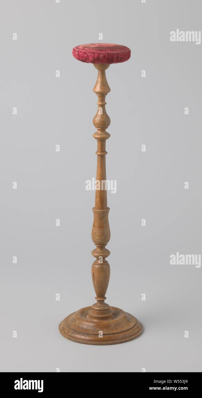 Perchero de madera retorcida, una base redonda destaca un tronco sobre el que se asienta un soporte redondo con terciopelo rosado, perchero hechas de madera de haya girado. Sobre