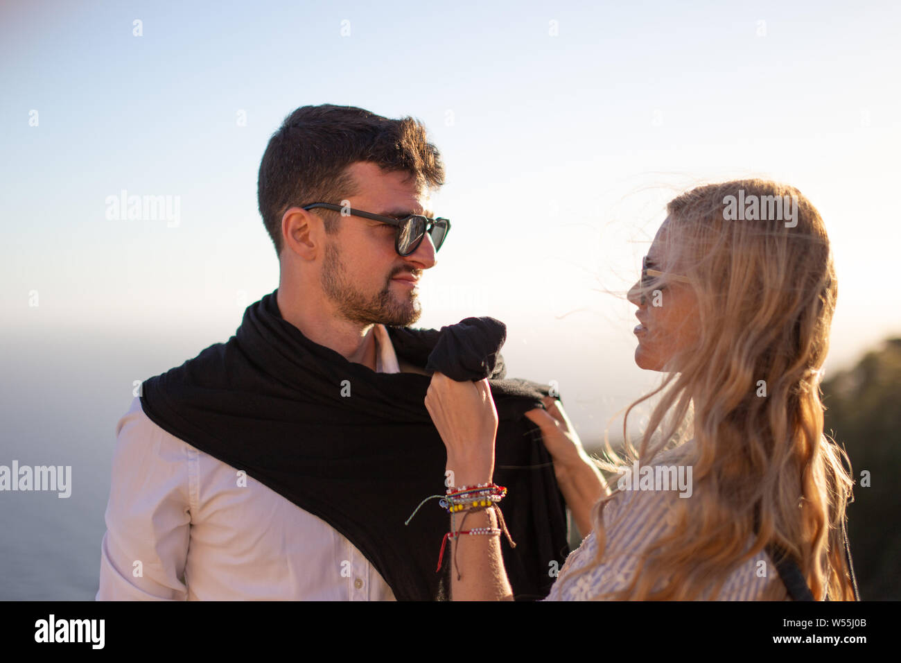 Joven pareja feliz en el amor sonriente en el atardecer, disfrutando de momentos juntos Foto de stock