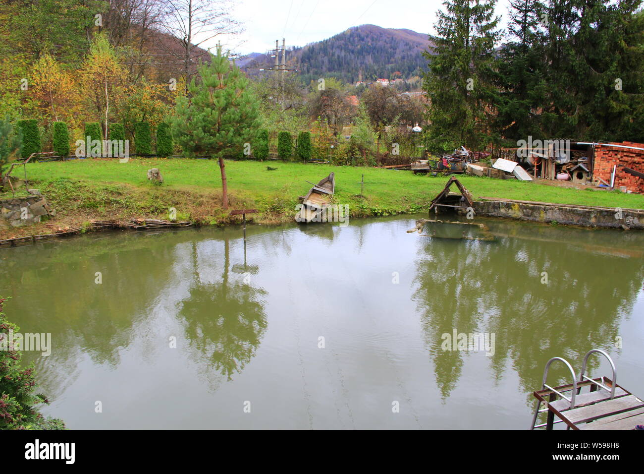 Criadero de truchas con lago privado entre montañas. Hermoso lago cerca de casa Foto de stock