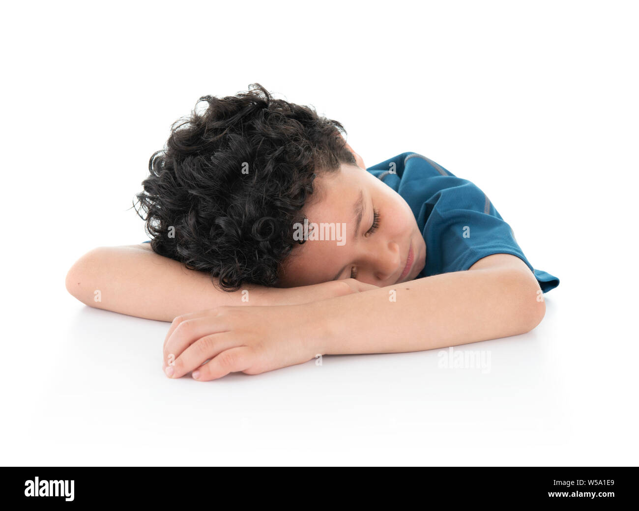 Un poco de jóvenes Exausted Lazy Boy se quedó dormido sobre la mesa blanca, Foto de estudio, aislado sobre fondo blanco. Foto de stock