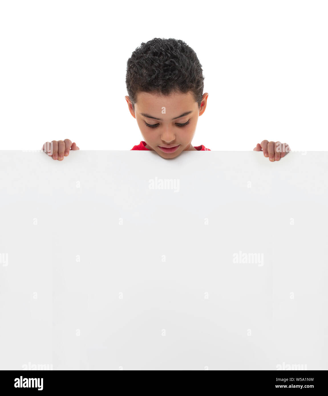 Un joven niño sosteniendo una pizarra blanca con copia en blanco el espacio, concepto de publicidad Foto de stock