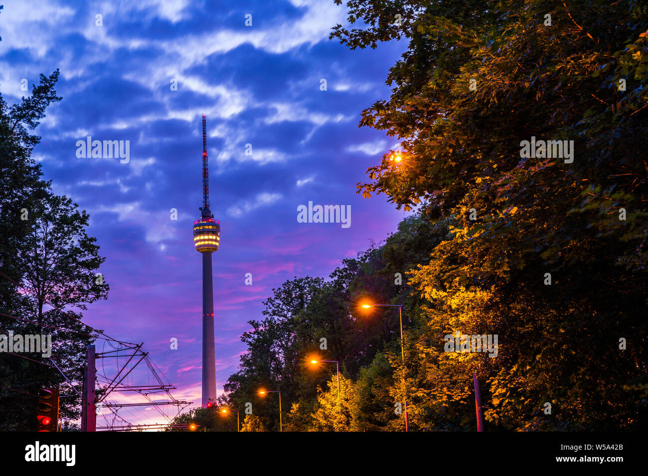 Alemania, cielo nocturno de torre de televisión de la ciudad de Stuttgart en bosque verde naturaleza del paisaje iluminado por las luces de la calle y el rojo cielo de la posluminiscencia Foto de stock