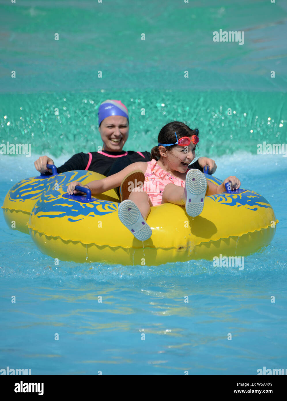 Una feliz familia musulmana, madre e hija, divertirse en la piscina de verano, concepto Foto de stock
