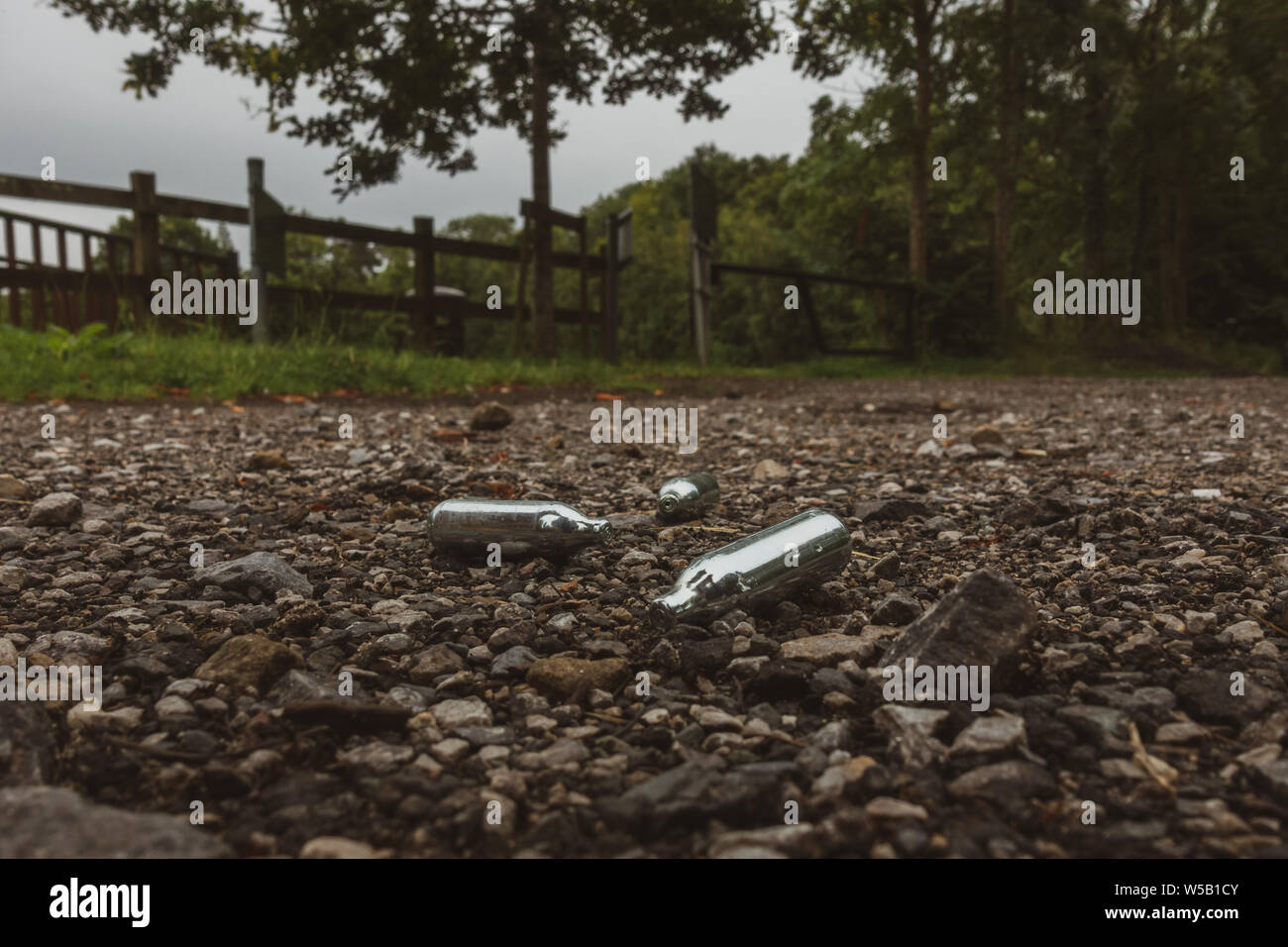 Descartan cannisters gas de óxido nitroso (gas hilarante) usada como una droga recreativa, en un parque en una zona rural. UK Foto de stock