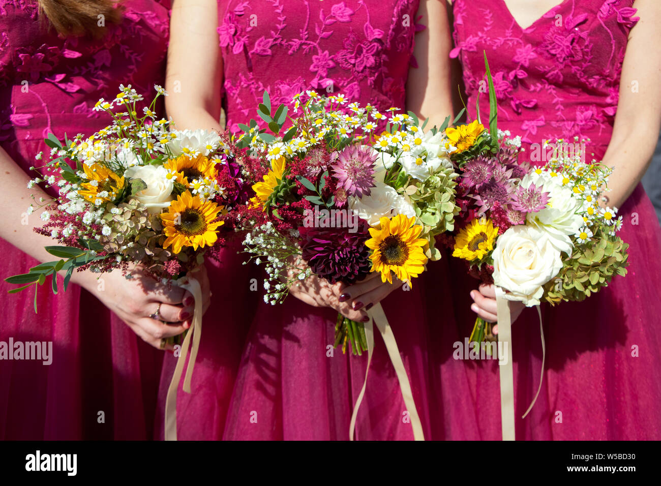 Tres damas de honor vestidos de encaje en color lila con ramos de flores  frescas, el enfoque selectivo Fotografía de stock - Alamy