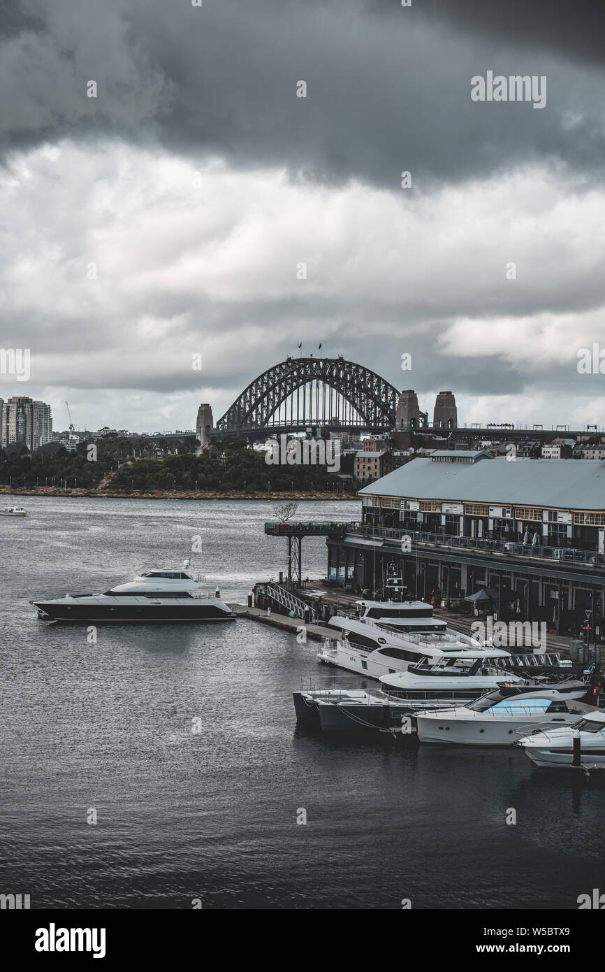 Pyrmont, Nueva Gales del Sur - Junio 24th, 2019: ominosas nubes penden sobre Jones Bay Wharf con el norte de Sydney y el Puente del Puerto de Sydney visibles en el ba Foto de stock