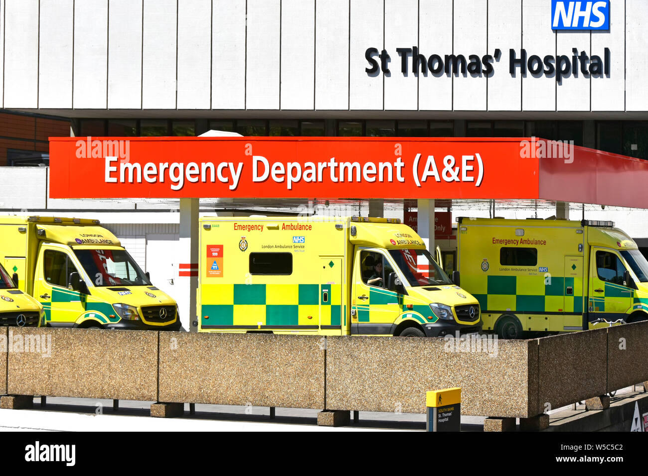 El servicio de ambulancias de Londres vehículos en St Thomas hospital NHS esperando en gota fuera de la zona A&E accidente departamento sanitario de emergencia edificio Lambeth UK Foto de stock