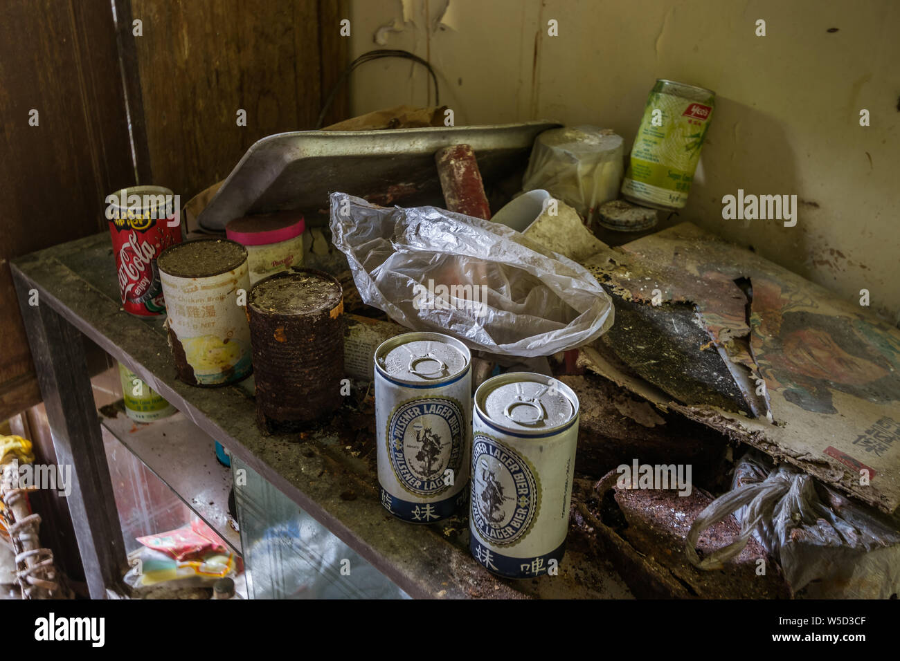 Latas oxidadas en una vitrina en la casa abandonada Foto de stock