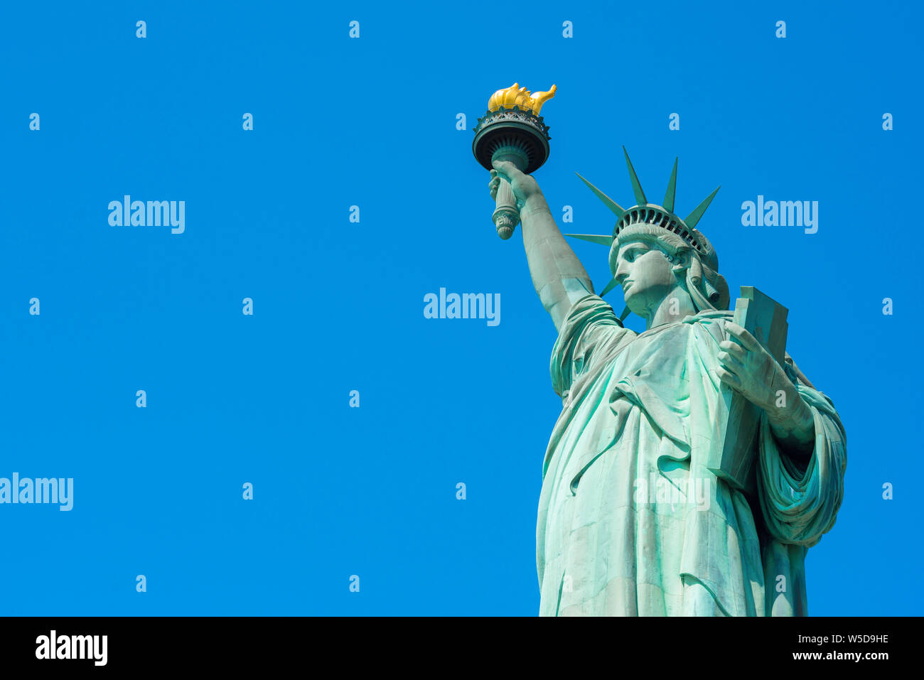 Símbolo de Estados Unidos, vista de la mitad superior de la Estatua de la libertad contra un cielo azul claro con copia espacio dejado, Liberty Island, Nueva York, EE.UU.. Foto de stock