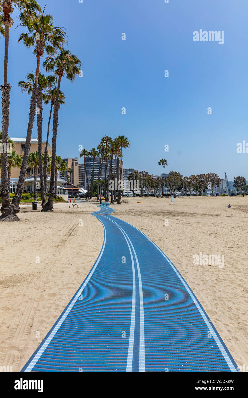 California, EE.UU. El 30 de mayo de 2019. Pasarela de color azul en Marina del Rey, playa de arena, palmeras y hoteles. Jornada soleada de primavera Foto de stock