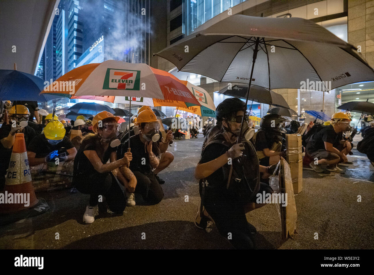 Los manifestantes utilizan paraguas y sus escudos para protegerse de escombros policía disparando balas contra ellos.Decenas de miles de manifestantes marcharon en pro de la democracia en Hong Kong central en otra ronda de demostración contra el gobierno. La policía antidisturbios utilizó gases lacrimógenos y balas de escombros contra manifestantes, a pesar del hecho de que la policía ha sido ampliamente elogiado por el público por su uso desproporcionado de la fuerza contra los manifestantes en el pasado las manifestaciones desencadenadas por el polémico proyecto de ley de extradición presentada por el Gobierno de Hong Kong. Foto de stock