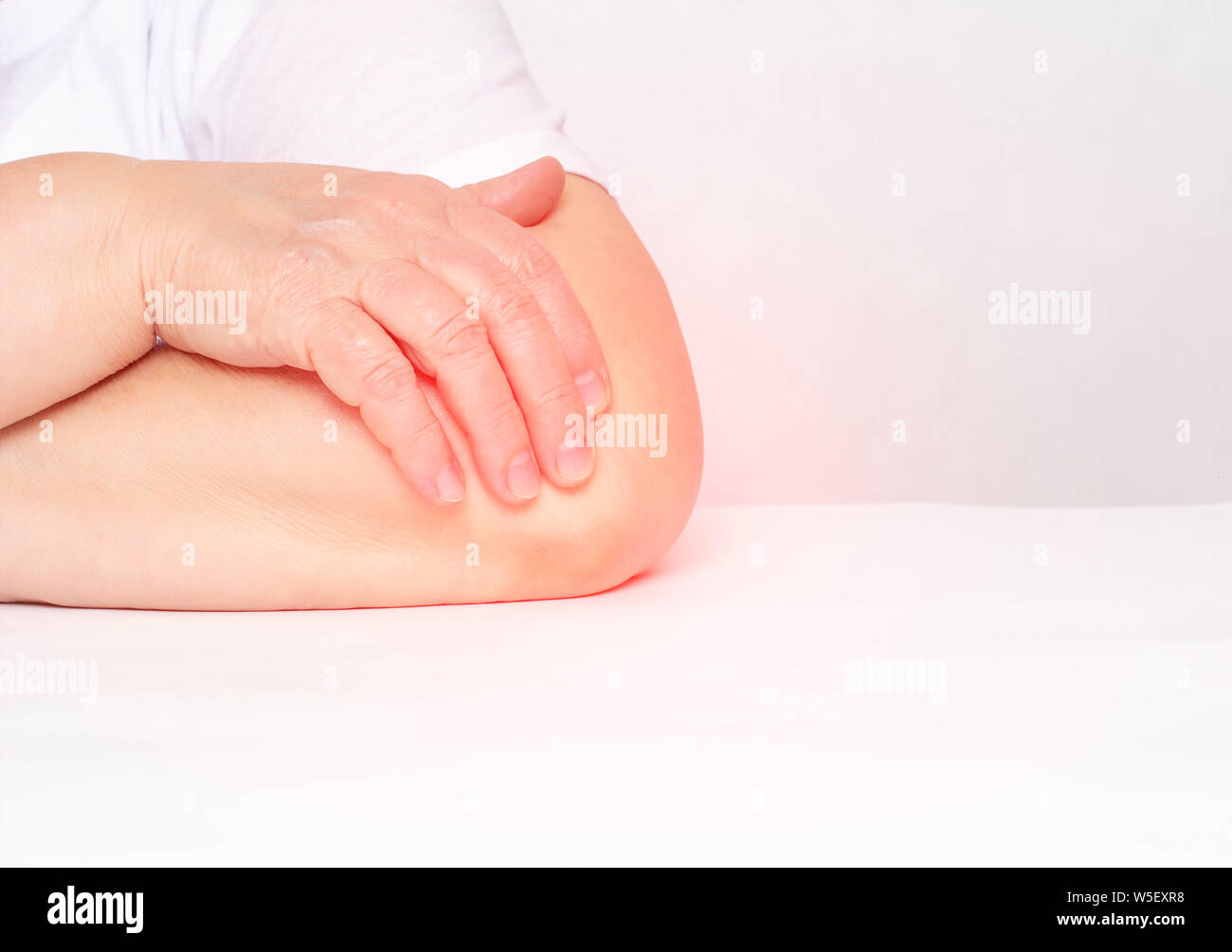 Dolor en la articulación del codo en una mujer, tendinitis y bursitis, lesiones degenerativas en la articulación, fondo blanco, copia el espacio, artrosis sinovial Foto de stock