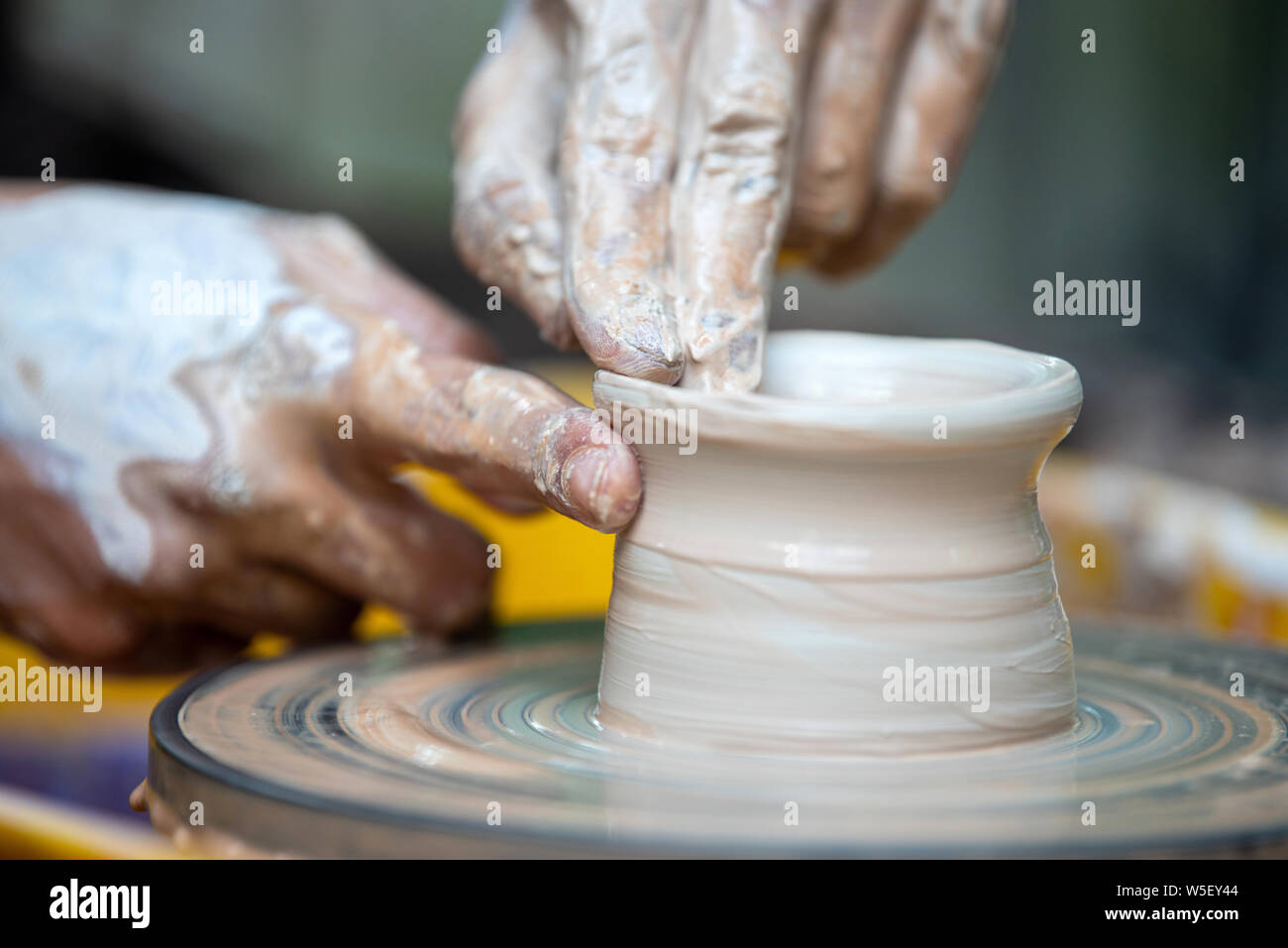 Las manos del alfarero. El alfarero hace platos de cerámica en torno de alfarero. El escultor en el taller hace producto de arcilla closeup Foto de stock