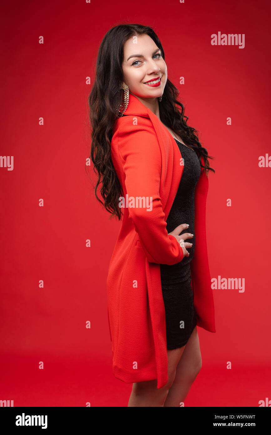 Seguros de Morena en el vestido negro y chaqueta roja posando Fotografía de  stock - Alamy
