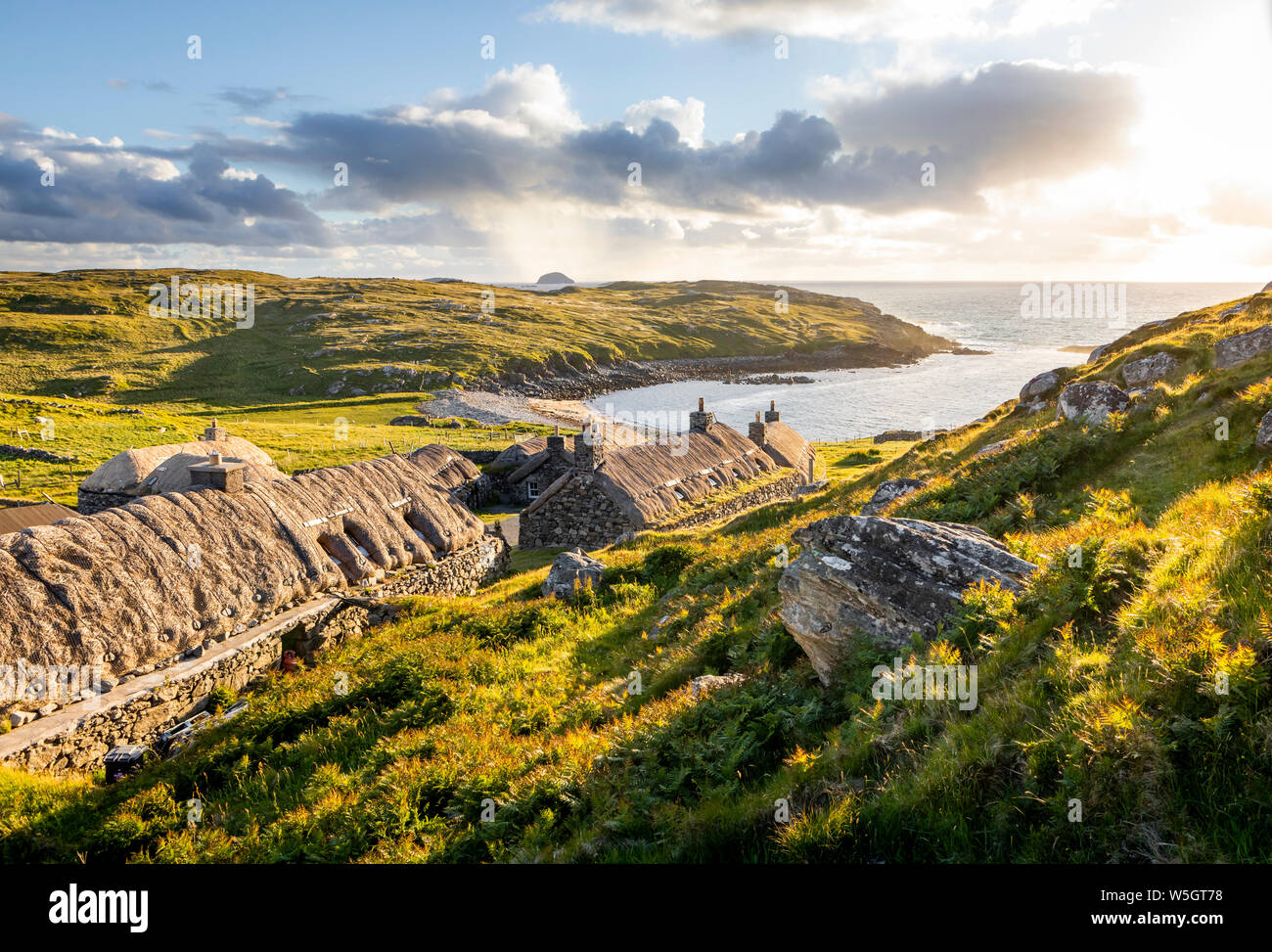 Gearrannan, Shottland- Junio 20, 2018: Gearrannan blackhouse aldea con casas con techo de paja en la isla de Lewis en una dorada luz del atardecer Foto de stock