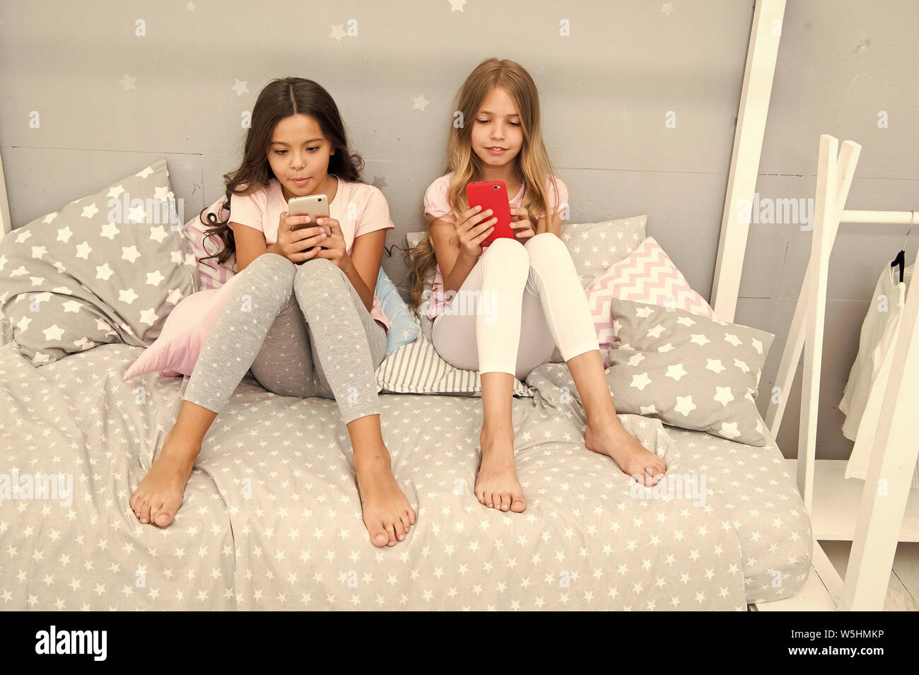 Explore la red social. Smartphone para entretenimiento. Kids Play móvil smartphone aplicación de juego. Concepto de aplicación de Smartphone. Ocio Girlish Pajama Party. Las niñas poco smartphone bloggers. Foto de stock