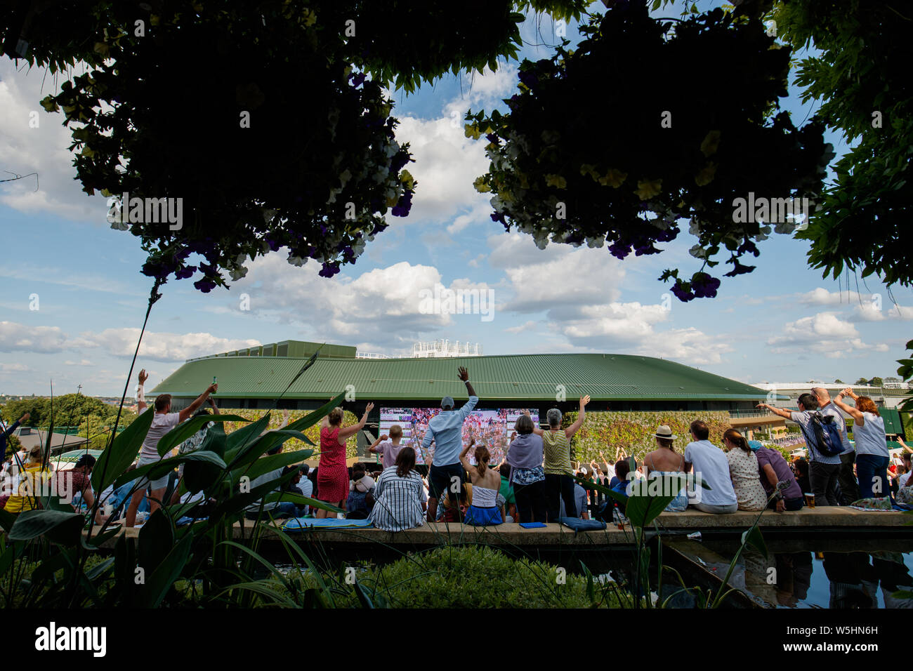 Los aficionados y espectadores de Henman Hill , Murray montículo o Aorangi Hill, con la gran pantalla el nº1 Corte durante el Campeonato de Wimbledon 2019. Foto de stock