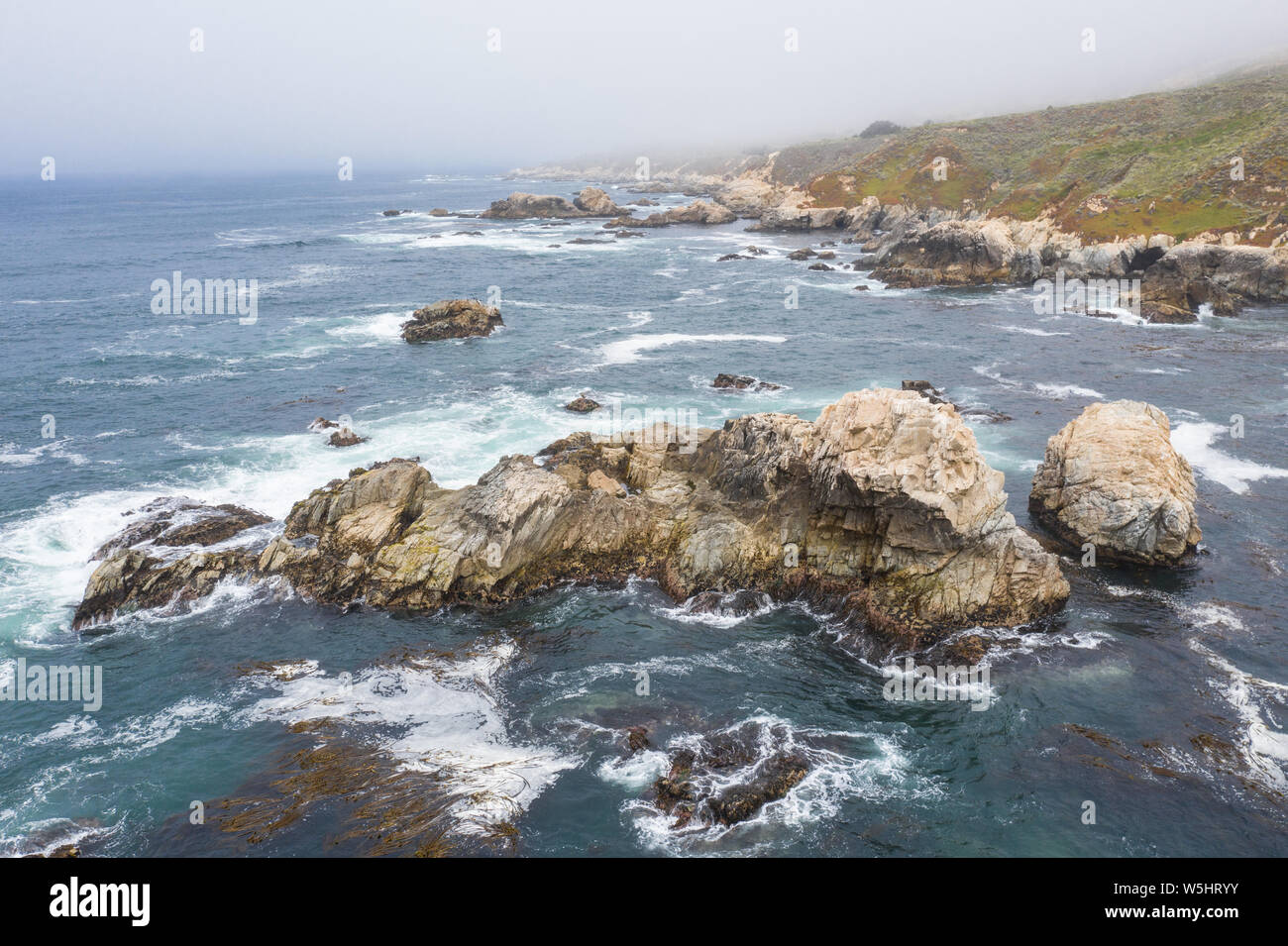 Visto desde una vista de pájaro, el Océano Pacífico baña contra el pintoresco y costa rocosa al sur de Monterrey, en el norte de California. Foto de stock